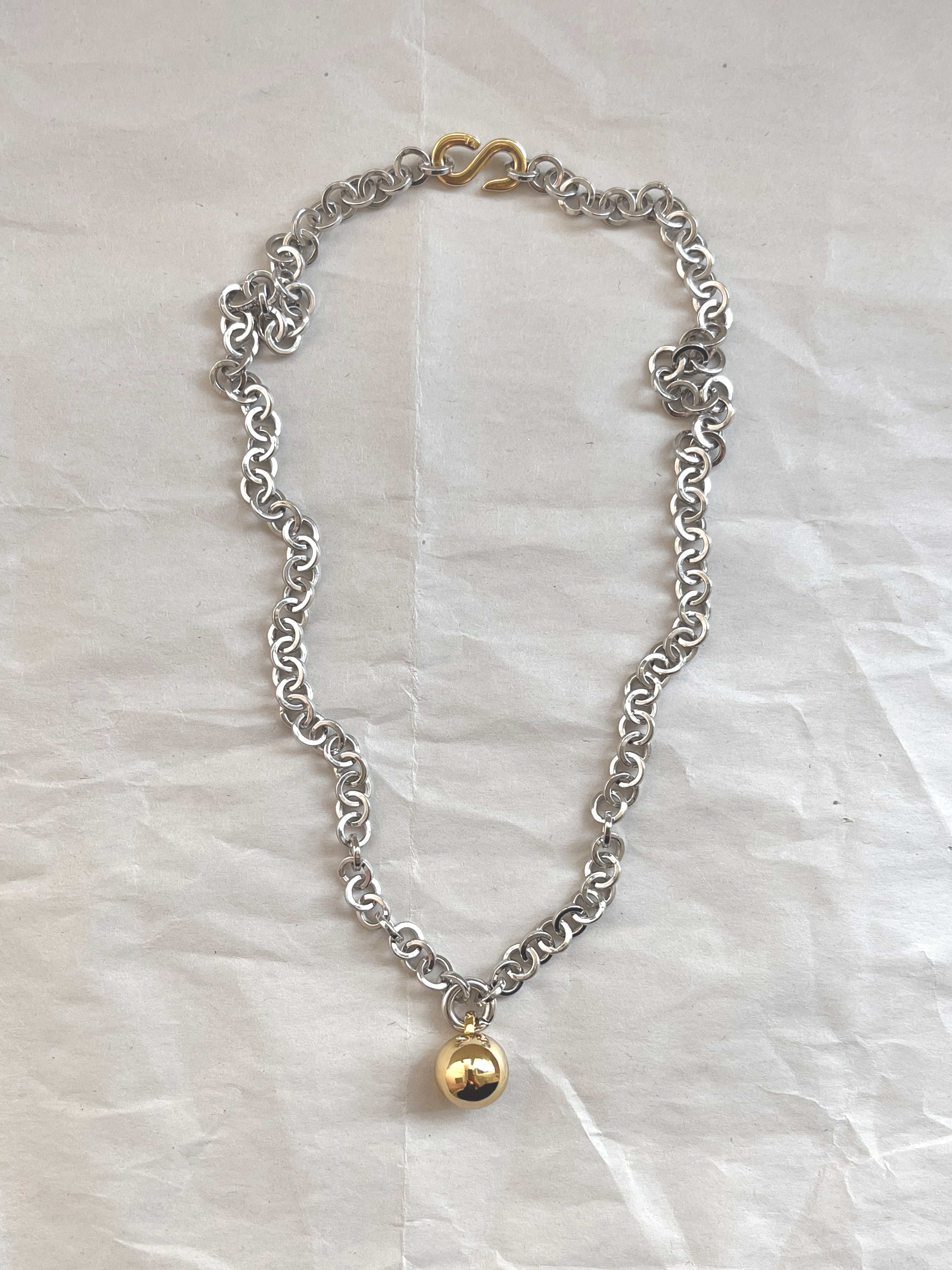 Laura Lombardi Two Tone Campana pendant with gold circular charm on white paper background.