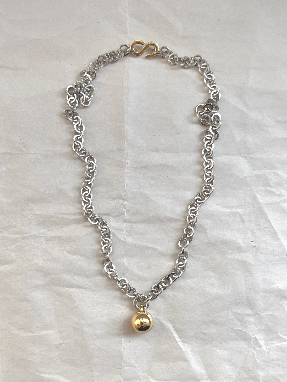 Laura Lombardi Two Tone Campana pendant with gold circular charm on white paper background.