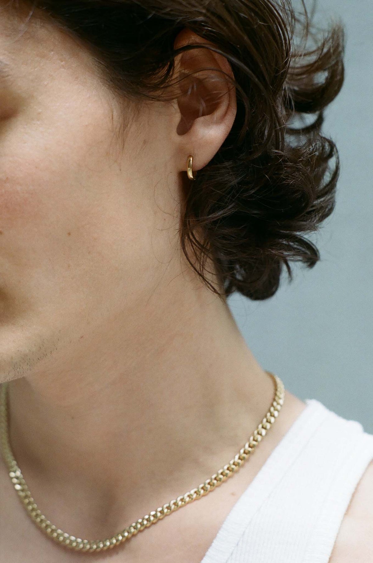 Model wearing Laura Lombardi gold Clutch Hoops.