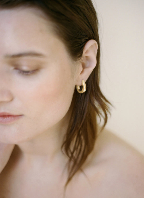Model wearing Laura Lombardi gold Corre Earrings