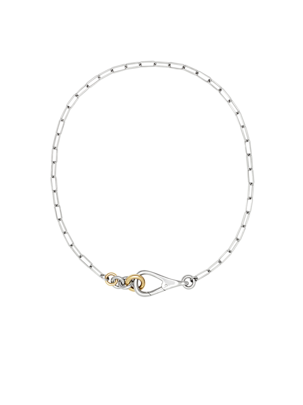 Two Tone Frena Necklace, a silver-toned oval chain necklace with a silver toggle clasp and gold jump ring, displayed on a neutral background.