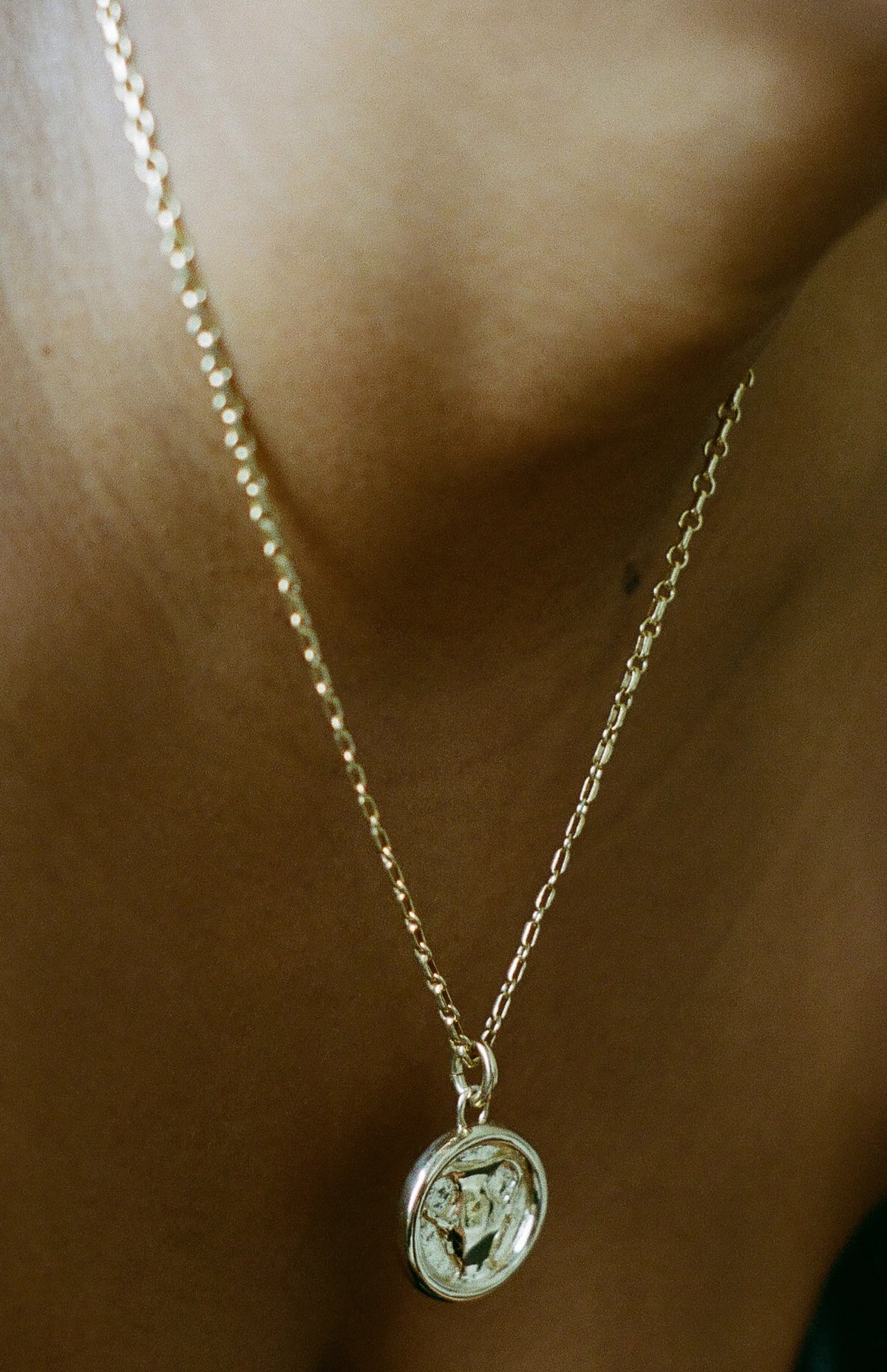 Model wearing gold AMS x LL Heaven Sip Pendant