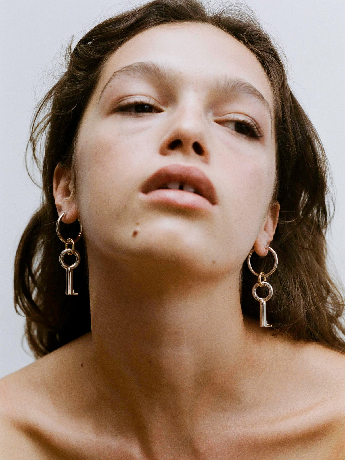 Close-up portrait of model wearing the Two Tone Permesso Earrings.