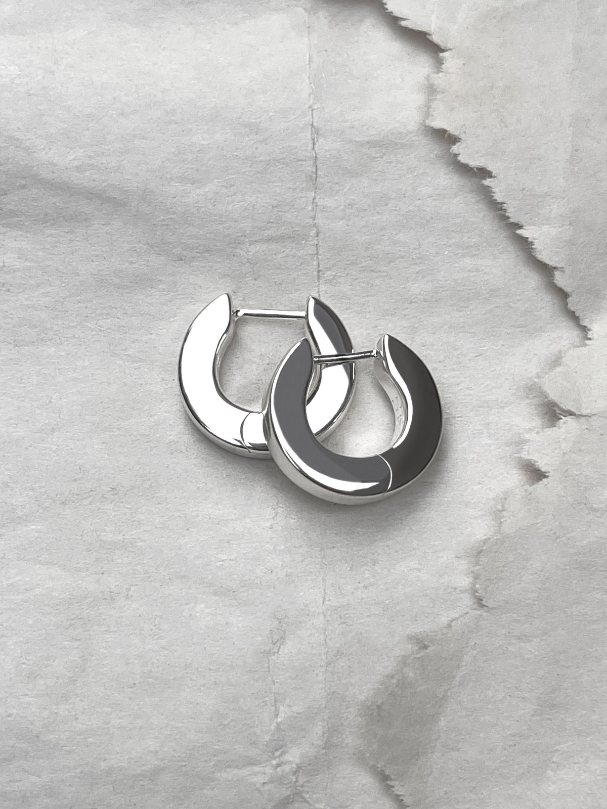 Laura Lombardi Silver Persa Earrings on paper background