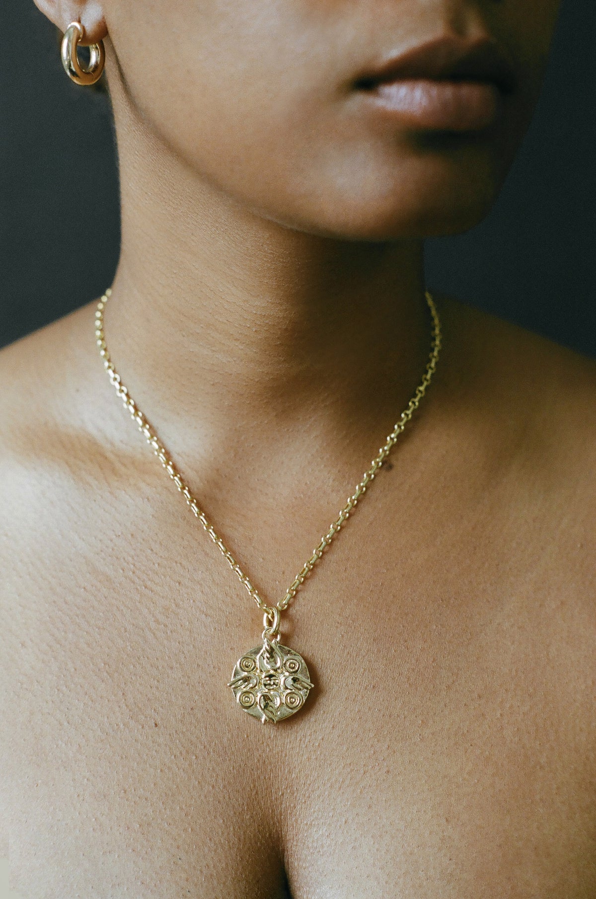 Model wearing AMS x LL gold Seraphim Pendant