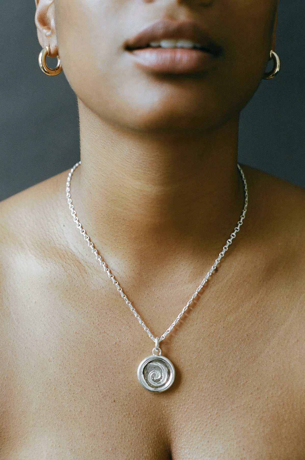 Model wearing AMS x LL Silver Spiral Pendant