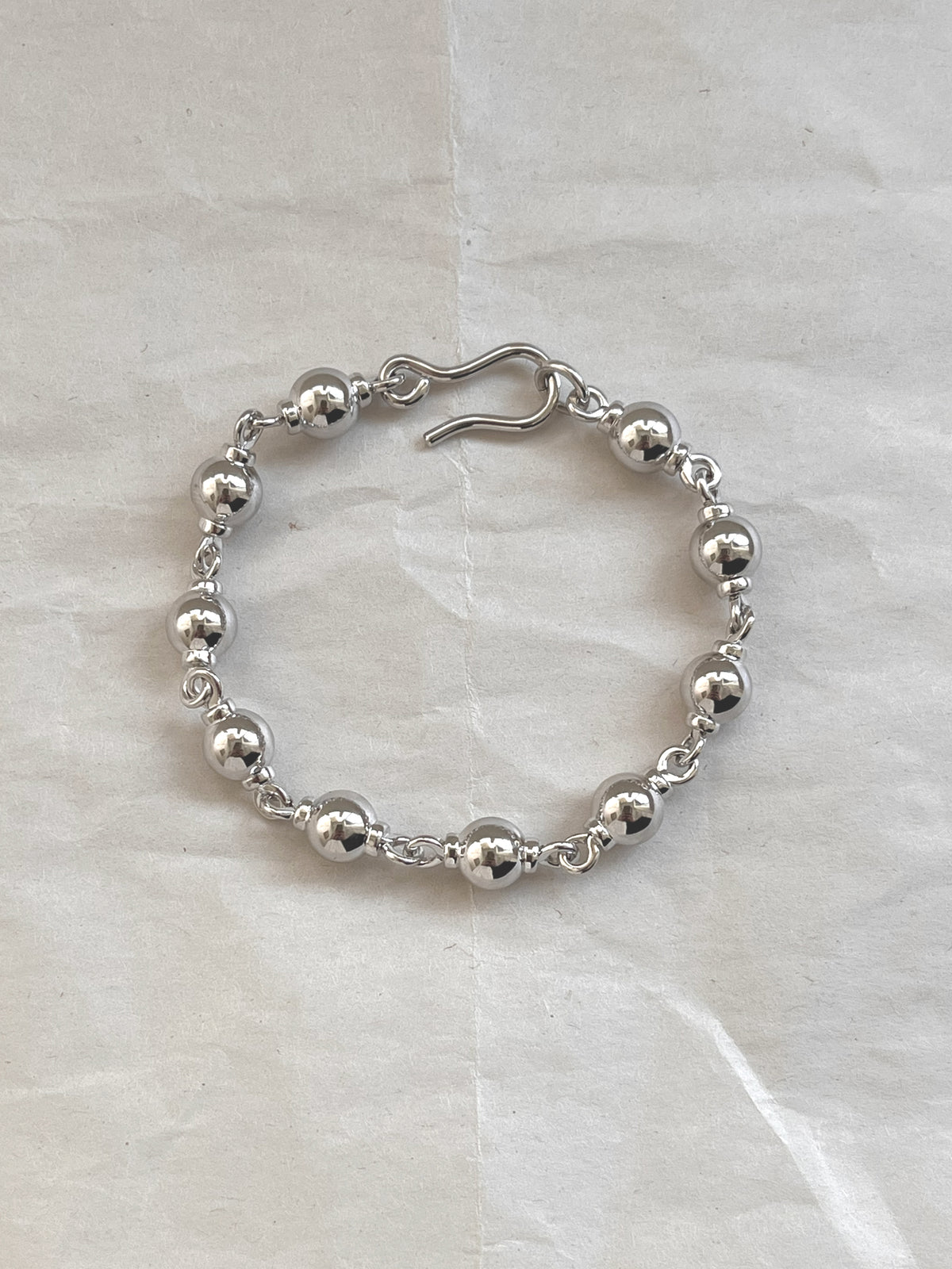 Laura Lombardi Silver Suona beaded bracelet on white paper background.