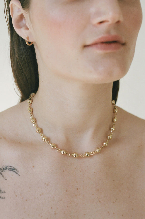 Model wearing Laura Lombardi gold Suona Necklace